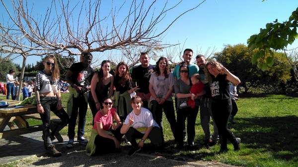 Grup de joves i adults posant contents al jardí sota un arbre sense fulles